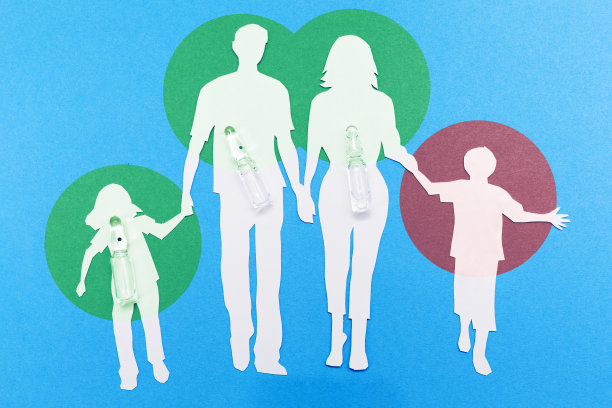 2019冠状病毒病疫苗接种概念。一个健康家庭的剪影，剪纸和安瓿在蓝色的背景。未接种疫苗者感染病毒的风险。平躺图片下载