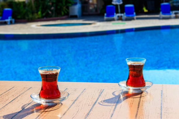 游泳池旁的桌子上放着热土耳其茶图片下载
