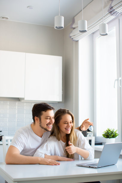 垂直的照片。与亲朋好友在线见面——在笔记本电脑显示器前的在线视频通话中，快乐微笑的情侣图片下载