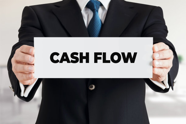 商人展示了一条写着“现金流”的横幅。企业财务的概念。图片下载