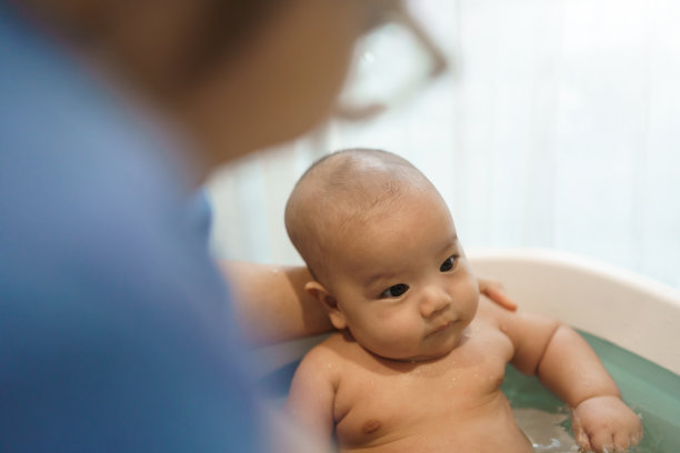 亚洲母亲在浴缸洗澡她的小男孩在家里。图片下载