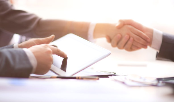 一个拿着平板电脑坐在会议桌旁的商人图片下载