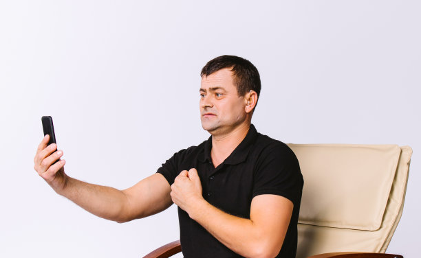 一位坐在皮椅上的老人做了个手势，并做了一个视频链接。白色背景。图片下载