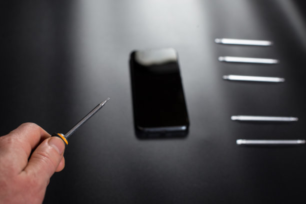 电子修理螺丝刀在手。智能手机黑色修复图片下载