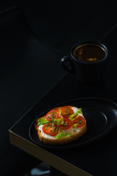 开胃菜，咖啡早餐，奶酪和番茄吐司。咖啡杯放在桌子上，顶部馈电，拷贝空间。黑暗的喜怒无常的背景图片下载