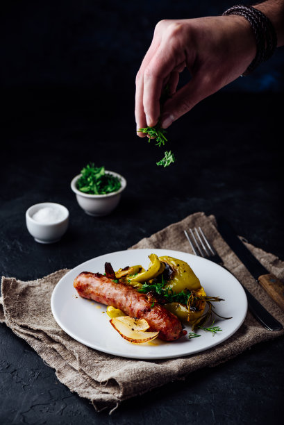 烤制猪肉香肠配青椒、洋葱和各种香草图片下载