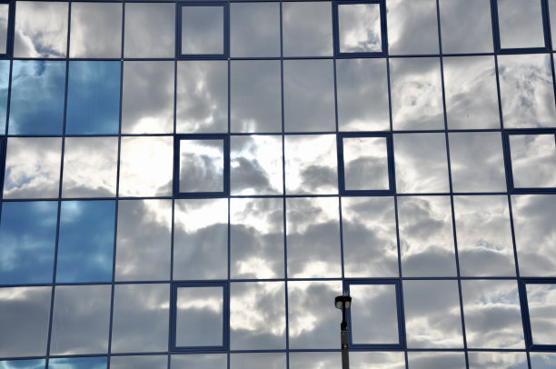 现代玻璃建筑的摩天大楼的商业中心与云反射图片下载