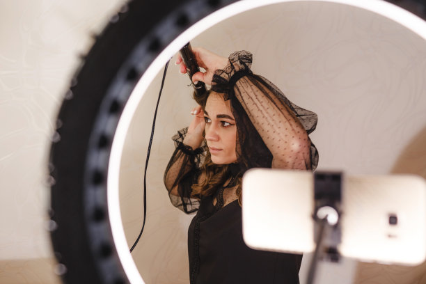 一位女博主兼美发师用她的手机拍了一段视频，告诉她的观众如何做发型。图片下载