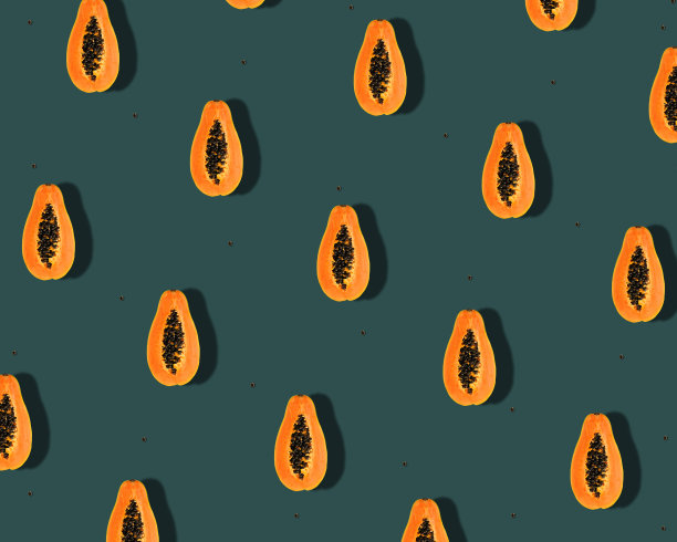 创意图案与橙色热带绿色木瓜果实和种子在潮水绿色的背景。图片下载