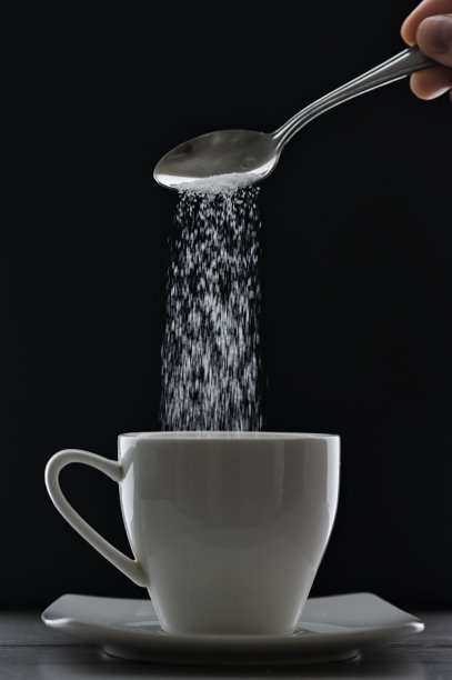 将茶杯或咖啡和糖勺放在黑色背景上图片下载