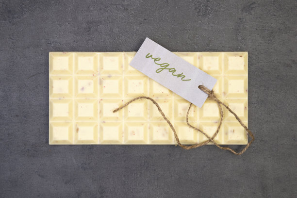 一块巧克力放在灰色的石头背景上，标签上写着“素食”和一串“n”图片下载