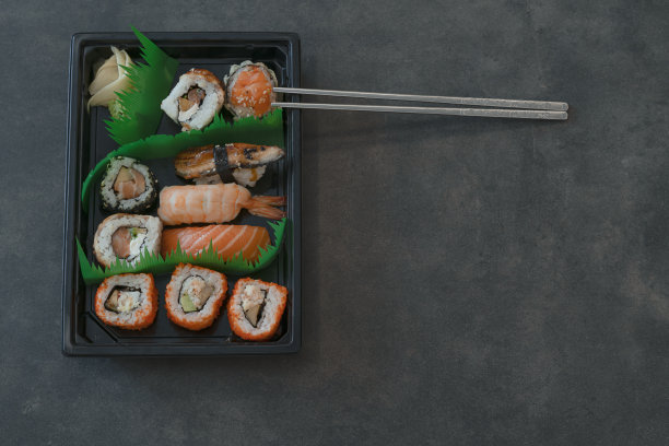 一套寿司和卷在交付箱与сhopsticks在黑暗的背景库存照片图片下载
