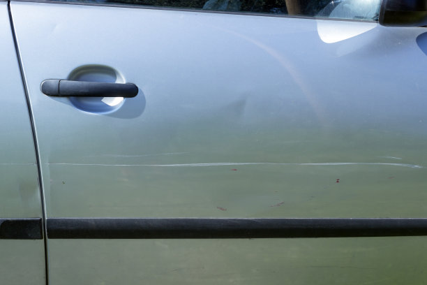 银色汽车门上的大划痕。概念-事故，汽车保险，交通事故。图片下载