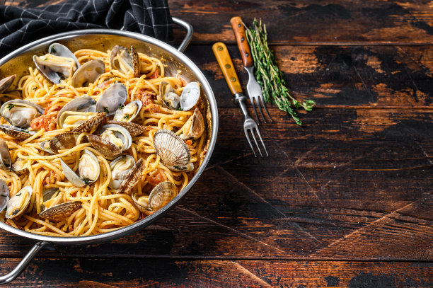 蛤蜊vongole海鲜意大利面平底锅里的意大利面。深色木制背景。前视图。本空间图片下载