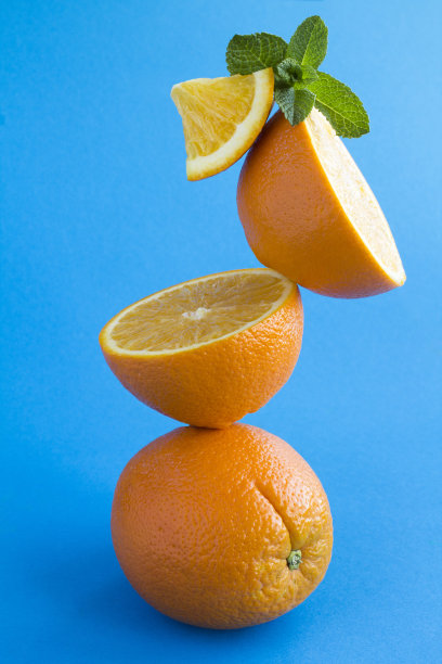 橙色的水果叠放在蓝色的背景上图片下载