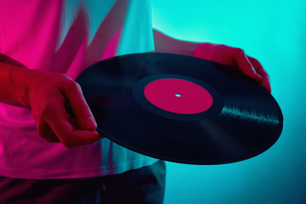 女人拿着霓虹灯下的复古唱片图片下载