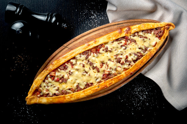 土耳其菜，以牛肉片、番茄和切达干酪为背景，以黑色为背景图片下载