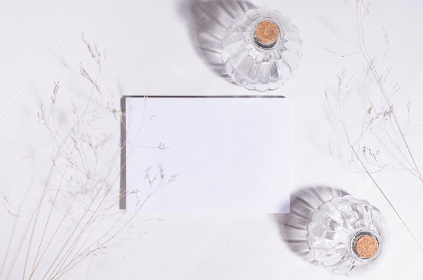 优雅脆弱的生活方式背景与空白纸的组合，干稻草，瓶子在阳光下，阴影在白木板上，俯视图。图片下载