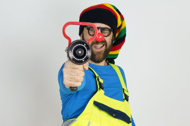 小丑消防队员手里拿着一个消防桶，扑灭了大火。图片下载