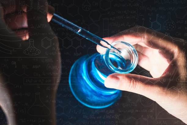 手握烧瓶与实验室玻璃器皿和试管在化学实验室的背景，科学实验室研究和发展的概念图片下载