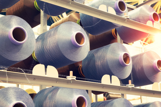 纺织厂工业织造机上的蓝色纱线卷轴图片下载