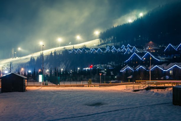 滑雪场被灯笼、木屋和圣诞树照亮。灯笼和花环照亮了房子。布科维尔山区的冬季度假胜地。乌克兰图片下载