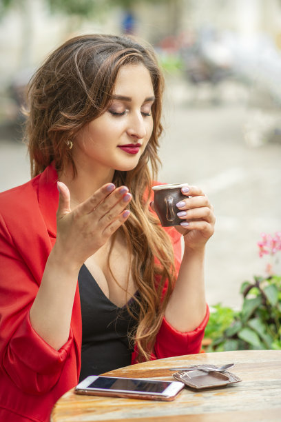 年轻漂亮的女人闻着咖啡图片下载