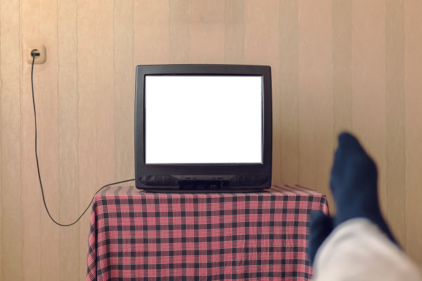 穿着黑袜子的男人正在看白屏幕的旧电视图片下载