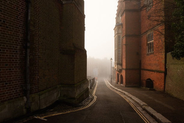 雾蒙蒙的道路之间的建筑物哈罗在英国山上图片下载