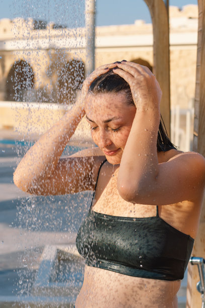 美丽的年轻女子在一个阳光明媚的日子在海边户外游泳。图片下载