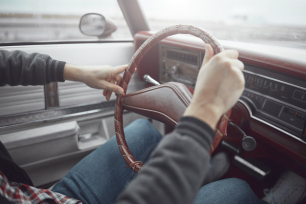 穿着复古衣服开着老式美国车的人。图片下载
