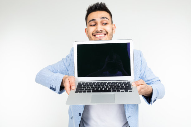 年轻的黑发男子微笑着对着摄像头拿着一个笔记本电脑屏幕，白色背景上有一个空白的模型图片下载