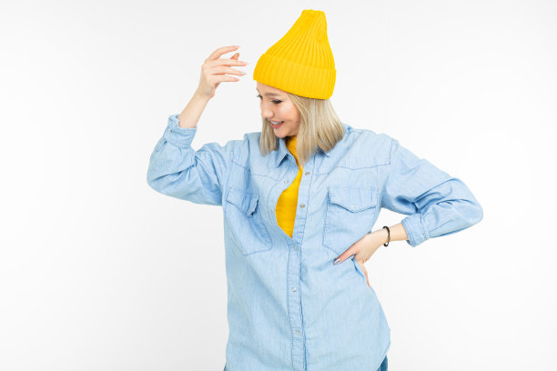 穿着蓝色衬衫和黄色毛衣的酷炫女孩在白色背景下摆姿势图片下载