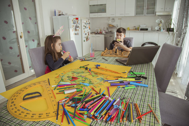 弟弟和妹妹花时间一起做他们的爱好象棋和绘画图片下载