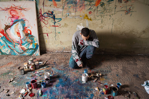 一个艺术家跪着完成了他的画。图片下载