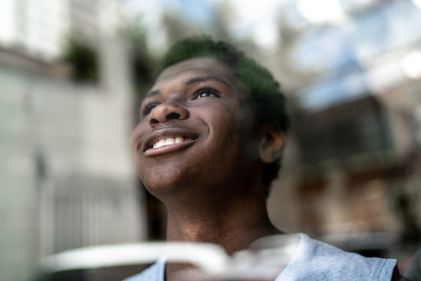 十几岁的男孩从家里的窗户往外看图片下载