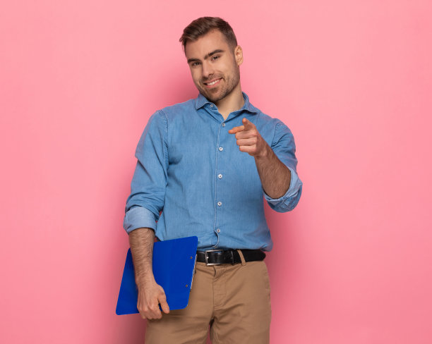 迷人的未剃须的随意男人指着手指和微笑图片下载