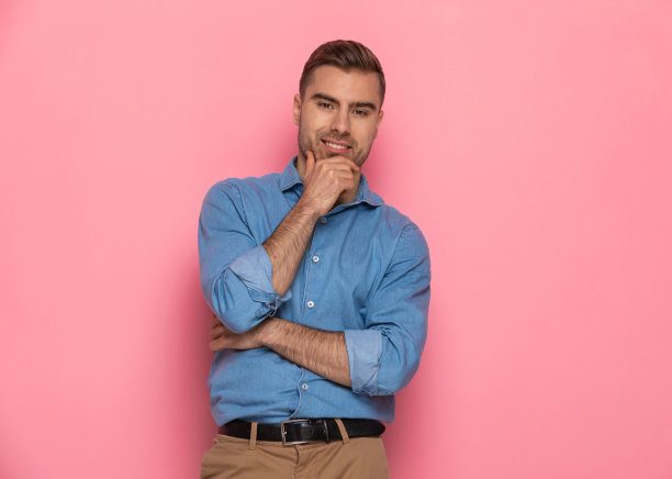 性感的年轻男子穿着休闲牛仔衬衫交叉手臂和调情图片下载