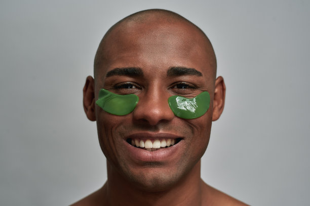 水凝胶美容贴片折叠在一个快乐的男人的脸上图片下载