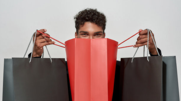 快乐的年轻非裔美国人拿着打开的包裹图片下载