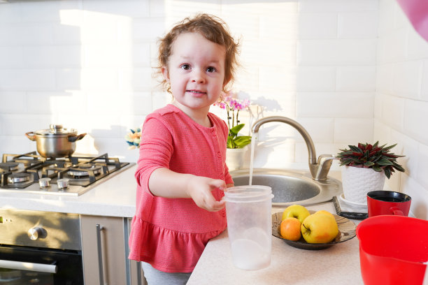 一个小女孩在厨房里用苹果准备健康食物图片下载