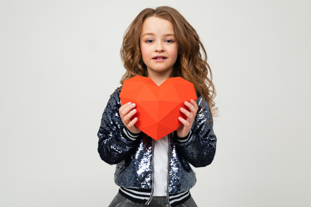 时尚的女孩拿着一张情人节的心形纸，白色的背景上有拷贝空间图片下载