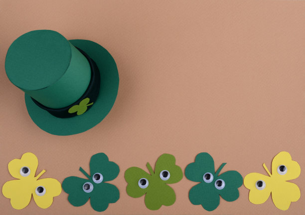 圣帕特里克节小精灵的帽子和三叶草的叶子和卡通塑料眼睛。图片下载