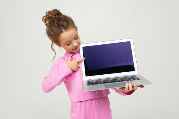 特写有吸引力的有趣迷人的婴儿在粉红色的服装显示笔记本电脑屏幕上模拟的白色背景图片下载