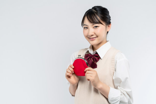 亚洲女学生拿着一个硬币钱包。图片下载