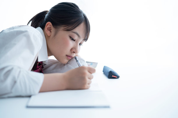 年轻的亚洲学生在教室里学习。图片下载