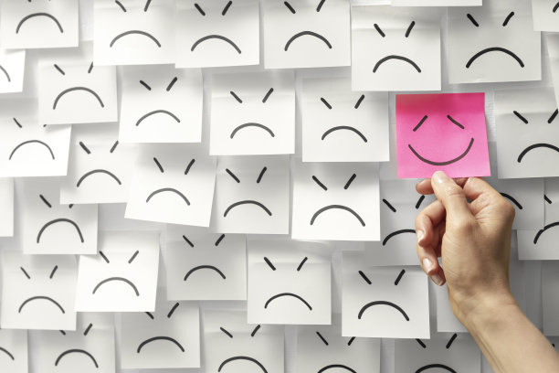 一个成功的商业想法的概念画在纸贴纸上。微笑和幸福背景上的悲伤音符。图片下载