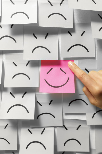 一个成功的商业想法的概念画在纸贴纸上。微笑和幸福背景上的悲伤音符。图片下载