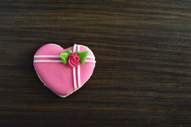 木制背景上的迷你心形糖饼干。前视图。图片下载