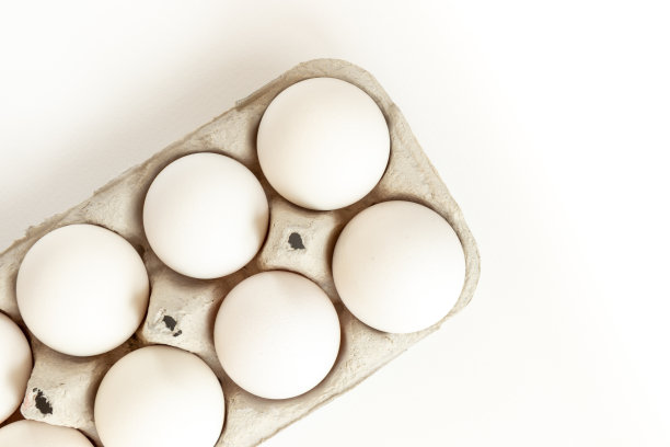 白色背景上有鸡蛋的纸板鸡蛋盒。图片下载